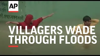 Villagers in Bangladesh wade through floods