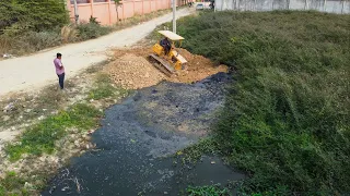 The first inauguration of a new project pour soil !! with bulldozer pushing soil in the mud.