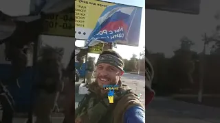 Ukrainian troops stripping a Russian billboard in liberated area.