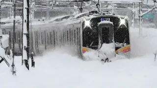 Local train & freight train running in heavy snow