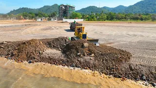 Bulldozer KOMATSU Push Rock In Water Sea  With Truck Transport Rock