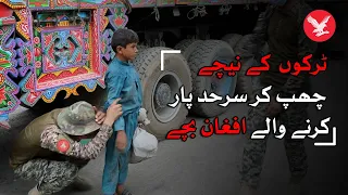 Afghan children crossing Torkham border under moving trucks