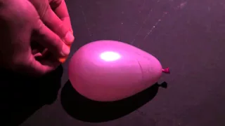 Slow motion water balloon popped with orange peel