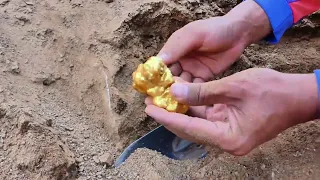 I am digging huge nuggets of gold treasure under stone at mountain near the river, mining exciting