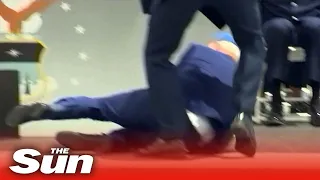 President Biden trips over 'onstage sandbag' and falls down during graduation ceremony