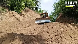 Very powerful Caterpillar D6R XL bulldozer working to level plantation roads