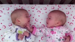 Identical twin girls engage in deep conversation