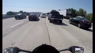 Clueless driver changes lane cutting off biker lane splitting path