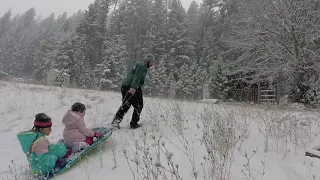 Pulling kids on a sled through fresh snow.