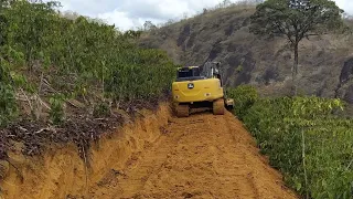 Cortando estrada com escavadeira hidráulica em meio a lavoura de café....