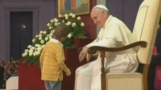 Young boy invades Vatican stage and hugs Pope Francis