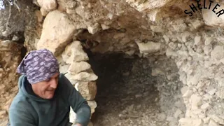 Building a stone shelter with a fireplace fire inside the survival camping in bushcroft, cooking