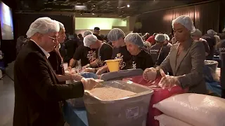 Volunteers pack meals for families at Intrepid Museum on 9/11 day