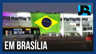 Enorme bandeira do Brasil é estendida na fachada do Palácio do Planalto, em Brasília