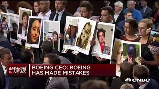 Families of 737 Max crash victims hold up photos during Boeing Senate hearing