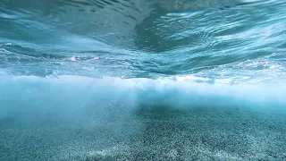 How it looks beneath a crashing wave - clear blue water in Crete
