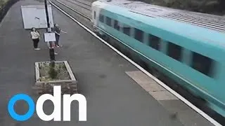 Train narrowly misses people crossing railway