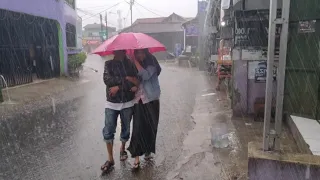 WALKING UNDER HEAVY RAIN AFTER A LONG DRY SEASON IN CITY TASIKMALAYA WEST JAVA INDONESIA VILLAGE