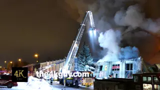 4K UHD - A soft focus view of a ladder truck spraying water onto building fire