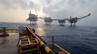 Fishing boat under offshore oil production platform Mar 2024