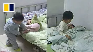 Boy puts little sister to sleep while mother is at work