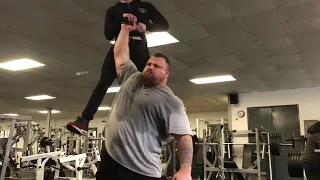 The Beast Eddie Hall lifting a man in one arm.