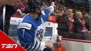 Finnish player signs autograph for Canadian fan while serving a penalty
