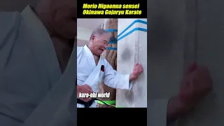 A man slams his fist into a concrete wall.