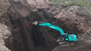 Extreme sand mine on the mountain slope, The skills of the excavator operator dredge high cliffs