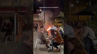 Diners sit outside a cafe in Bordeaux, France enjoying wine amid a raging fire lit by demonstrators