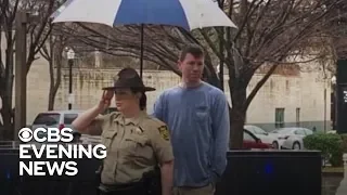 Stranger holds umbrella for sheriff's deputy saluting fallen officer