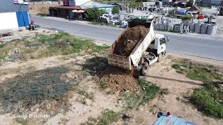 Busy start up new project by trucks dumping soil with Mitsubishi Bulldozer pushing