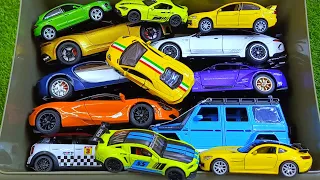 Box full of various miniature cars Peugeot, Jaguar, Pagani, Hyundai, Cadillac One, Opel, DHL 30