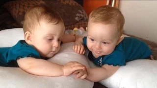 Identical twin babies talk and hold hands Part 2 while one rolls over for the first time!