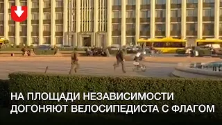 Люди в форме догоняют велосипедиста на площади Независимости