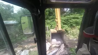 Cat 314C loading demo material into a dumpster