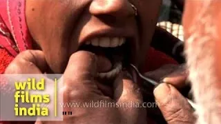 Street dentist gives anesthetic injection to patient on road