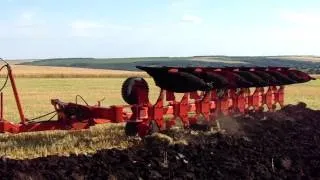 Плуг оборотный Оптикон Мастер А8 по полю с трактором New Holland T8