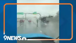 People ride scooter on Colorado highway during rainstorm