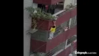 Man in China hangs off building to rescue toddler