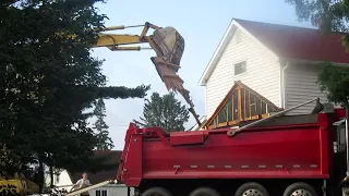 Excavator Loads Demolition Debris into Dump Truck