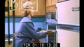 1950s Interior Refrigerator. Woman Places Food in Oven. Auto-Timer