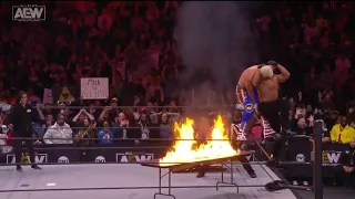 CODY RHODES AND ANDRADE GO THROUGH THE FLAMMING TABLE