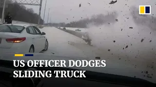 Moment quick-thinking US police officer dodges truck sliding down an icy highway