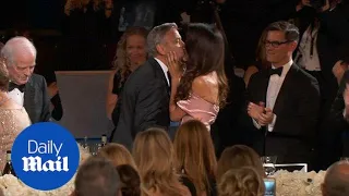 Amal Clooney kisses George as he is honoured by the AFI