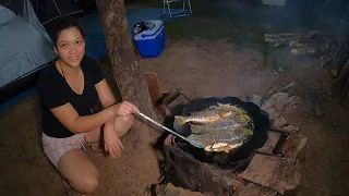 Acampamento pescaria peixe frito no disco de arado no fogão a lenha na beira do lago