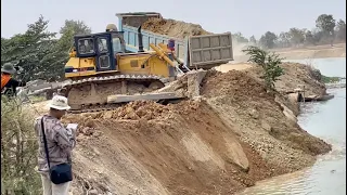 Best action Bulldozer D60p and dump truck pouring soil into river