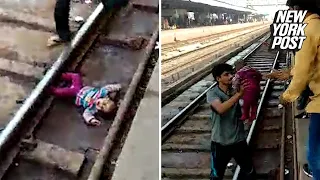 Baby defies death and misses being run over by train