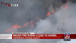 Brush fire burns close to homes