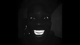 Black man smiles laughing in dark￼